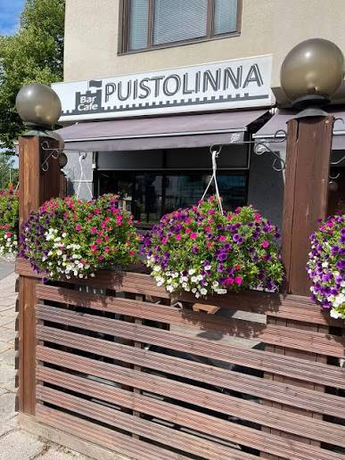 Ravintola Puistolinnan sisäänkäynti ja kukilla koristeltu terassi